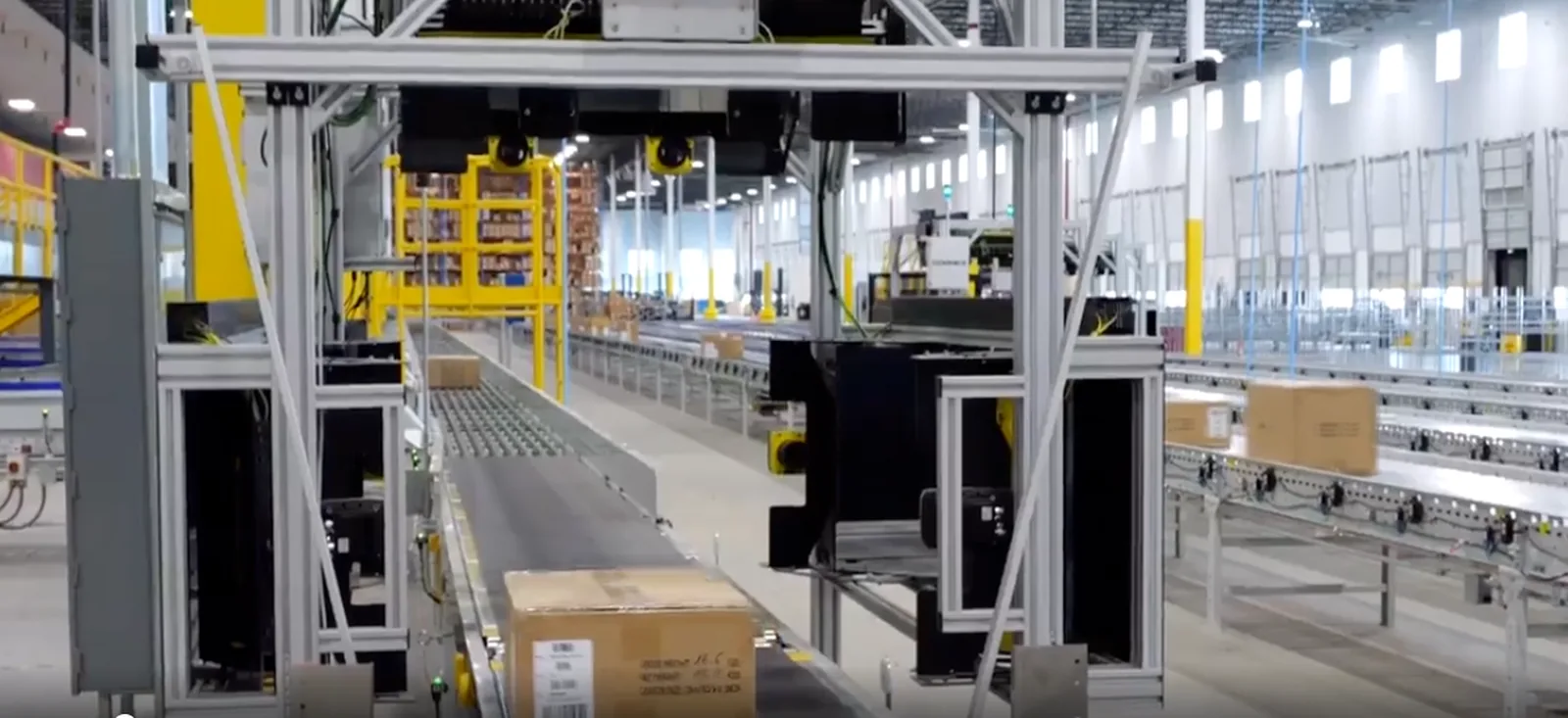 Automated scanning gantry over a carton conveyor in a modern fulfillment center